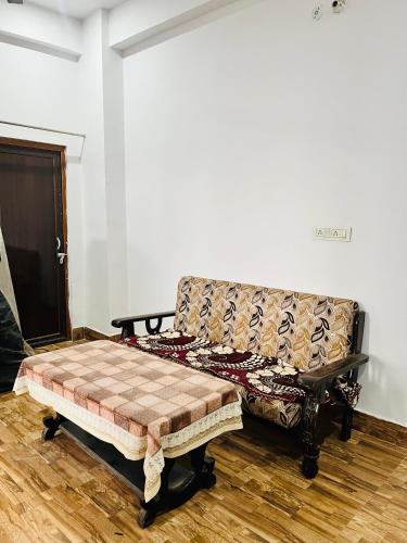 a couch sitting in a room with a wooden floor at Rr Complex in Nalmatha