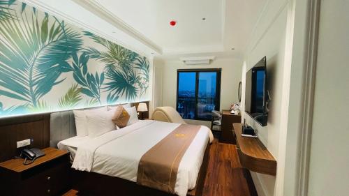 a hotel room with a large bed and a television at Glory Hotel Vĩnh Yên in Nhân Mỹ