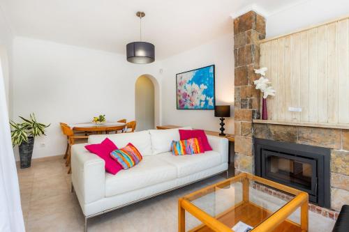 a living room with a white couch and a fireplace at Es Claper Cala Ratjada in Cala Ratjada