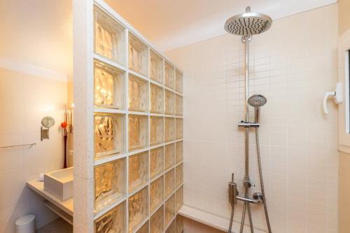 a bathroom with a shower with a tile wall at Es Claper Cala Ratjada in Cala Ratjada