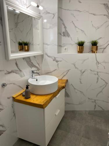 a white bathroom with a sink and a mirror at To Petrino Serifos in Livadakia