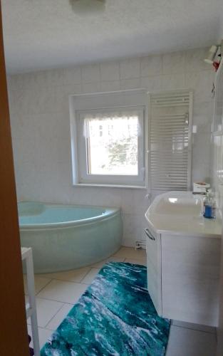 a bathroom with a tub and a sink and a bath tub at Weitblick am Hankehübel in Hohnstein