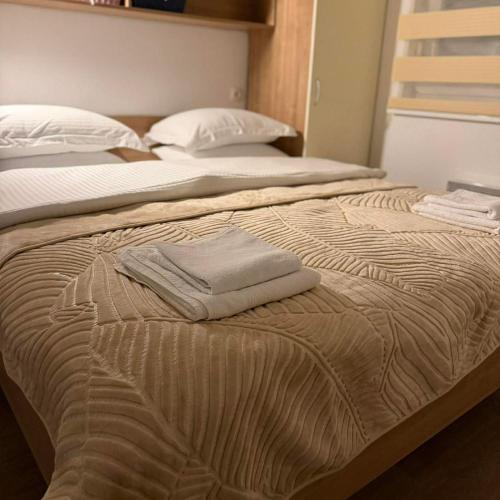 two beds in a bedroom with a towel on the bed at Neretva Paradise Mostar in Mostar