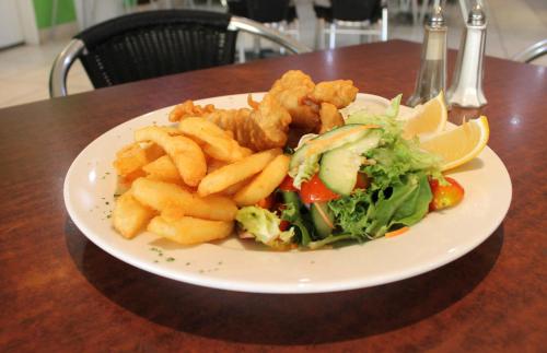 a plate of food with a salad and fries at Rocky Glen Hotel Motel Gladstone in Gladstone
