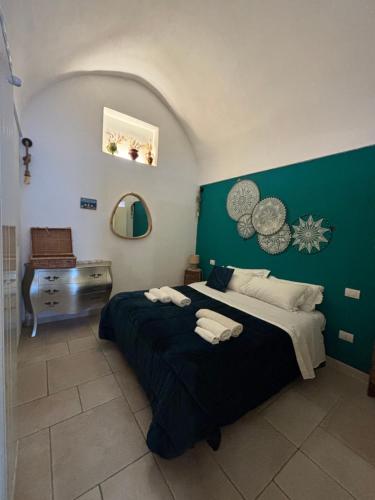 a bedroom with a large bed with a green wall at DOMUS MARIS in Monopoli