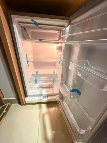 an empty refrigerator with blue tape on its door at Etqan Al Mashair Two in Mecca