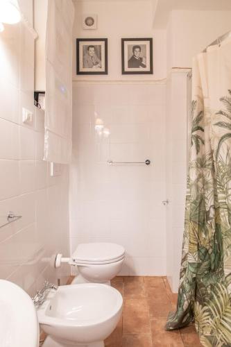 a white bathroom with a toilet and a sink at Boschetto 58 in Rome