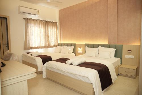 a bedroom with two beds and a window at Samyak Stay in Ujjain