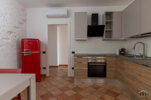 a kitchen with a red refrigerator and wooden cabinets at Vetera Boutique by IXIHOME in Varese