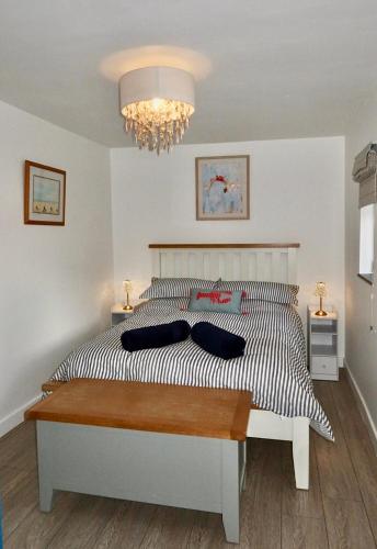 a bedroom with a large bed with a chandelier at Little Barn, Greendale Farm in Barnstaple