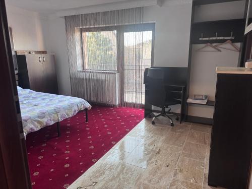 a bedroom with a bed and a desk and a computer at Vila cu trandafiri - Cozy Apartments Studio cu pat matrimonial in Bragadiru