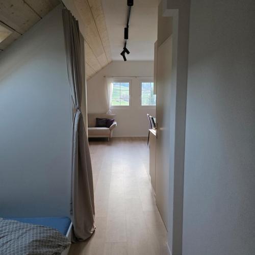 a hallway of a room with a bed and a window at Einzigartige Schlafkojen in Herisau