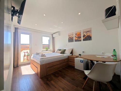 a bedroom with a bed and a desk and a table at PAVLIN Bed & Breakfast in Šenturska Gora