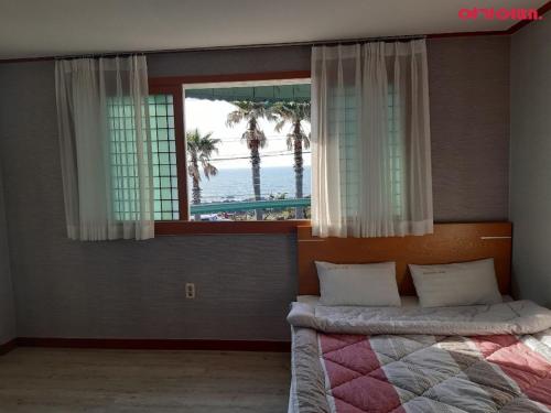 a bedroom with a bed with a view of the ocean at Jeju Island Love in Jeju