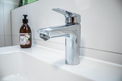 a bathroom sink with a faucet and a bottle of soap at Ferienwohnung Bela in Wangen im Allgäu