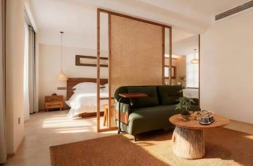 a living room with a green couch and a bed at Wuzhen FortuneCourt Hotel in Jiaxing