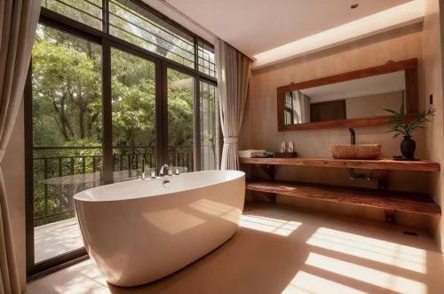 a bathroom with a tub and a large window at Wuzhen FortuneCourt Hotel in Jiaxing