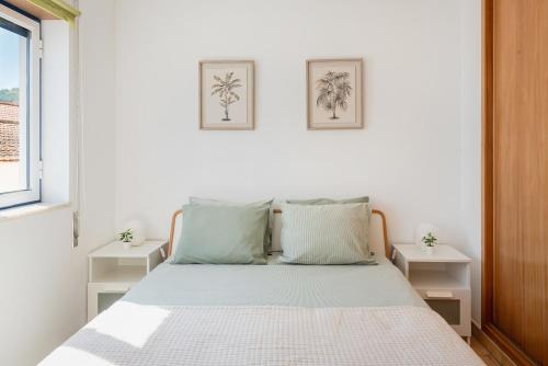 a white bedroom with a bed with two night stands at Casa de Baixo in Odeceixe