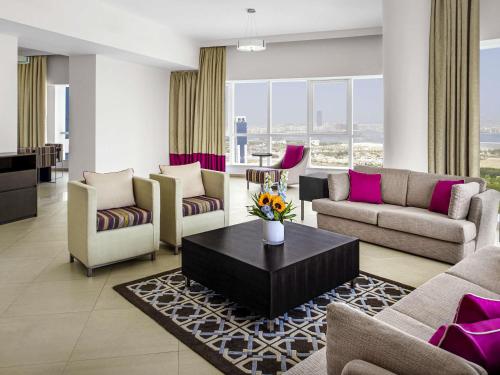 a living room with couches and a table at Adagio Premium Dubai Al Barsha in Dubai