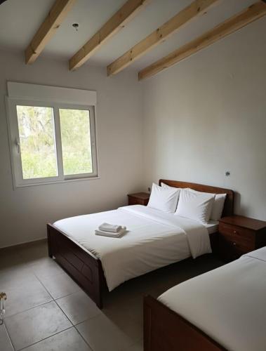 a bedroom with two beds and a window at Villa Laguna -house by the beach in Karavómilos