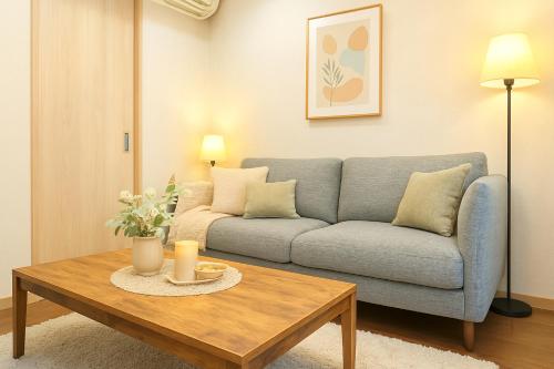 a living room with a couch and a coffee table at Kyobashi house Entire house for rentー 京橋一軒家完全貸切 in Osaka