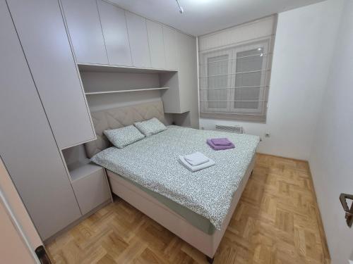 a small bedroom with a bed and a window at Apartman Ana Bijeljina in Bijeljina