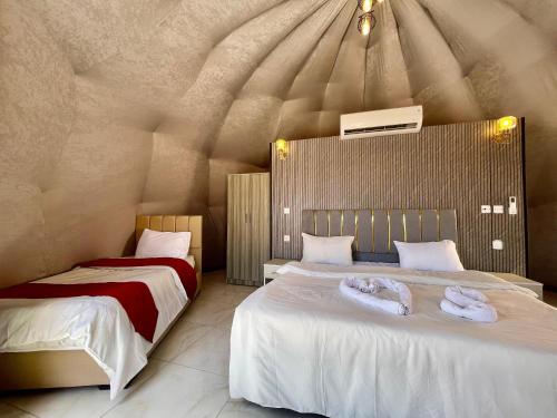 a bedroom with two beds with towels on them at Solara Rum Camp in Wadi Rum