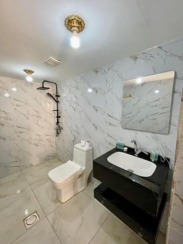 a bathroom with a white toilet and a sink at Solara Rum Camp in Wadi Rum
