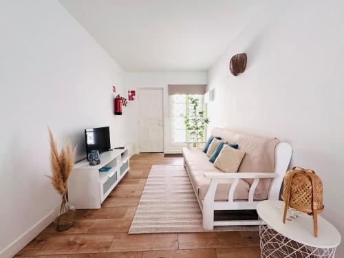 a living room with a couch and a tv at Casa do Mar - Reconnect - T2 com pátio junto à praia in Ovar