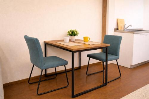 a wooden table with two chairs and a table with a sink at Kyobashi house Entire house for rentー 京橋一軒家完全貸切 in Osaka