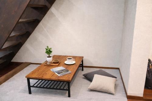 a coffee table with a plant on it in a room at Kyobashi house Entire house for rentー 京橋一軒家完全貸切 in Osaka