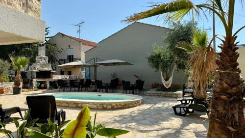 a courtyard with a pool and chairs and a building at Olea Apartments in Potos