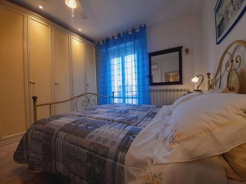 a bedroom with a large bed with a blue curtain at B&B L'Incancellata in Corinaldo