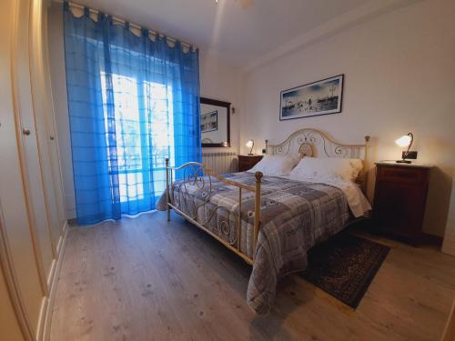 a bedroom with a bed and a window with blue curtains at B&B L'Incancellata in Corinaldo