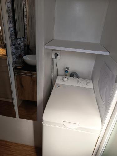 a washing machine in a small room with a sink at Mobile home in Quimper