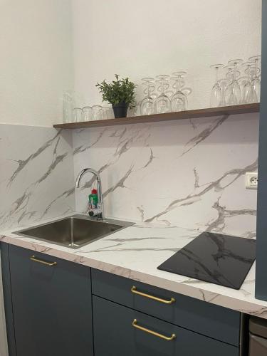 a kitchen with a sink and a marble counter top at La Parenthèse de Foch in Le Puy-en-Velay