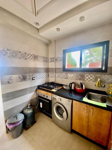 a kitchen with a washing machine and a sink at Genova surf house in Imsouane