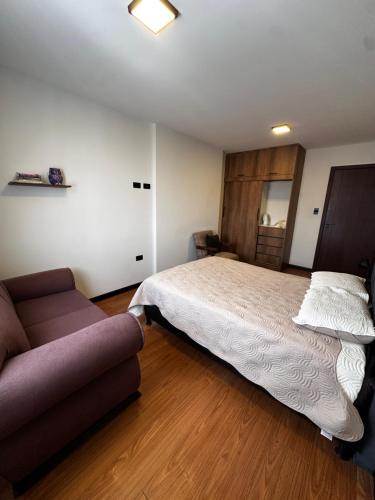 a bedroom with a bed and a couch at Departamento exclusivo! in Cochabamba