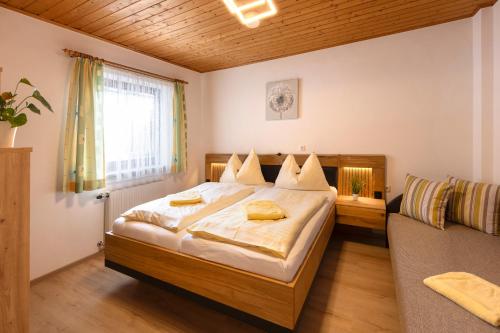a bedroom with a large bed and a couch at Bauernhof Klausbauer in Grossarl