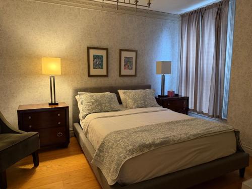 a bedroom with a bed with two lamps and a window at Washington Park Inn in Albany