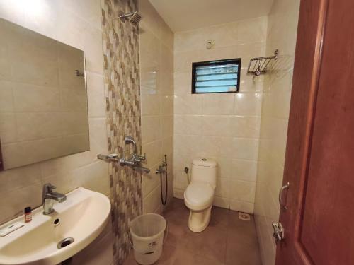 a bathroom with a white toilet and a sink at Aurelia by Jackfruit in Arambol