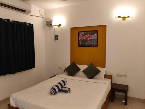 a bedroom with two beds and a picture on the wall at Aurelia by Jackfruit in Arambol
