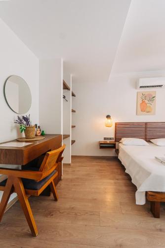 a bedroom with a bed and a desk with a mirror at Riserva Urla in Urla