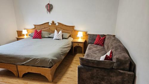 a bedroom with a bed and a couch at Appartamenti Croz del Re 2 in Andalo