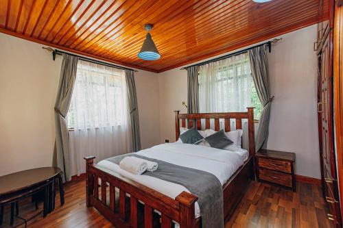 a bedroom with a bed and a wooden ceiling at Karen Crown 5BR Villa in Nairobi