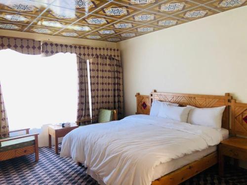 a bedroom with a bed and a coffered ceiling at Ameer lodge in Hunza Valley