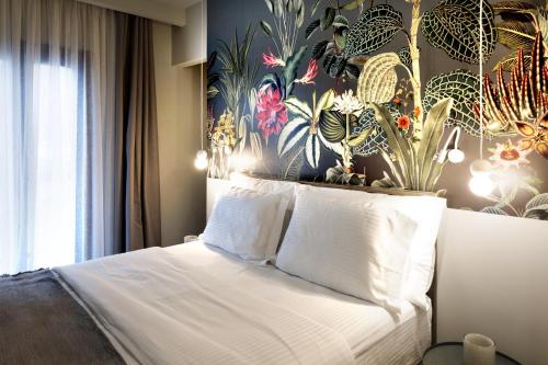 a bedroom with a bed with a floral wall at Angels Riva Boutique Residences in Kastoria