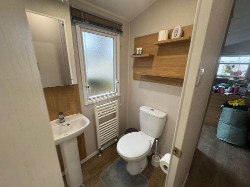 a small bathroom with a toilet and a sink at Stylish large static caravan gold rated 3BR Slp 8 Thorness Bay in Porchfield