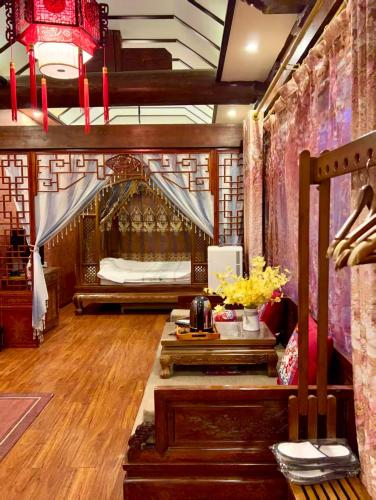 a room with a bed and a table with flowers at Pingyao HongJingYuanGuesthouse in Pingyao