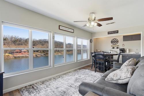 a living room with a ceiling fan and large windows at Waterfront Condo near Marina in Branson